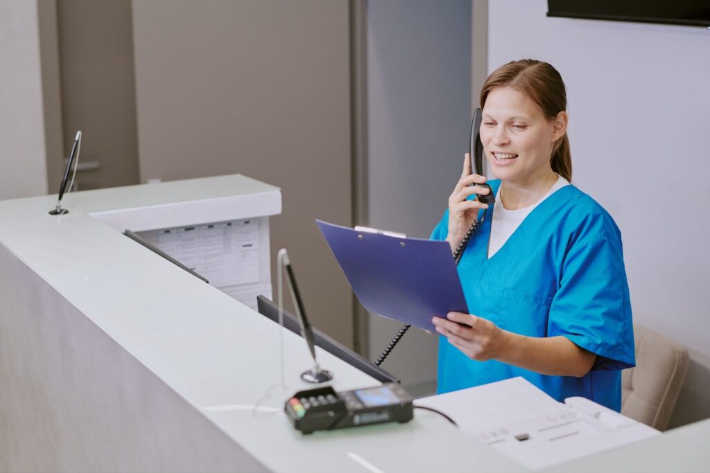 Clinic receptionist speaking to client on phone